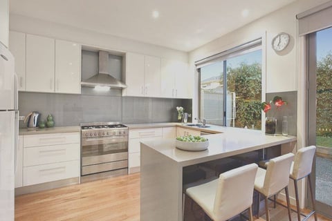 a kitchen with a large window and a table with chairs