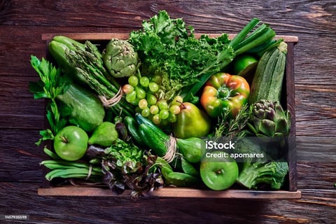 a wooden crate with vegetables and fruits on it