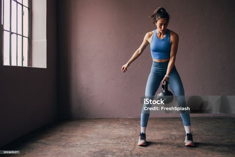 a woman holding a kettlebell