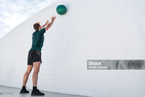 a man reaching up to catch a ball