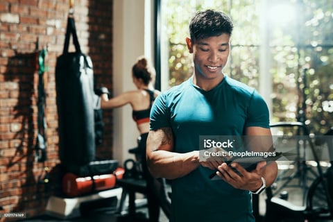 a man in a gym with a tablet and a woman in a gym