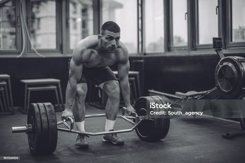 a man is squatting on a barbell