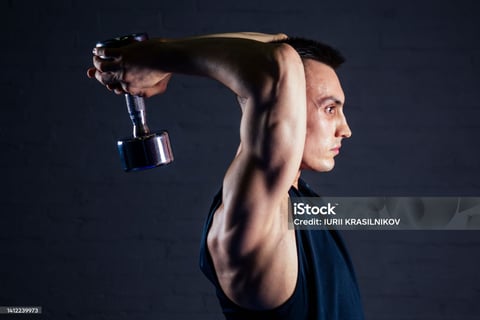 man doing dumbbell extension exercise