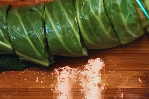 dark cabbage leaves sliced on cutting board