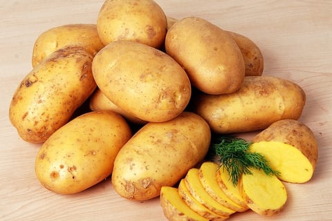 sliced potatoes with whole yellow potatoes