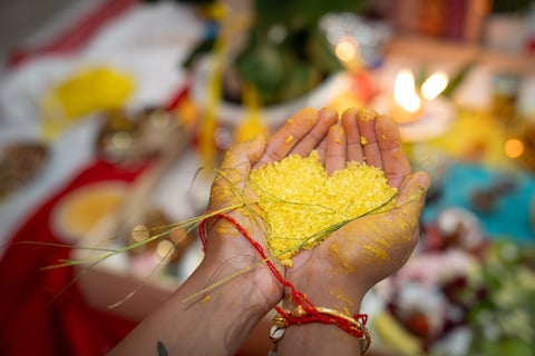an India groom holding a heart shaped piece of rice
