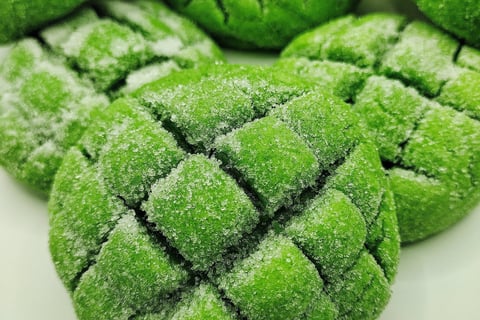 a plate of green cookies with sugared sugar on top