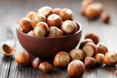 a bowl of nuts and hazells on a wooden table