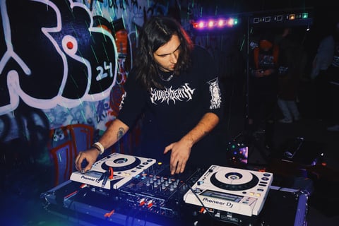 a man in a black shirt is playing a dj - Creechur