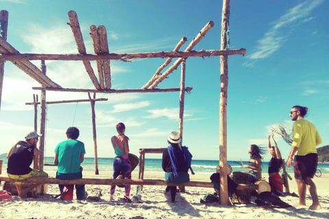 groupe de personne de dos jouant des tambours sur une plage
