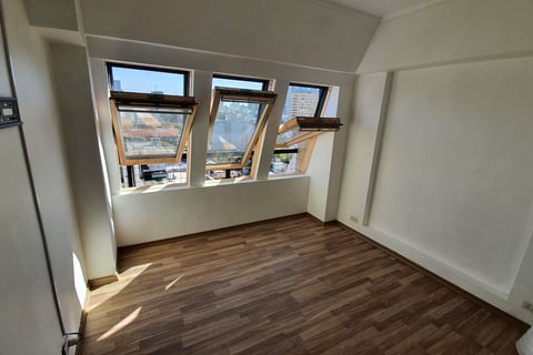 a room with a window and a wooden floor