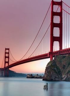 a bridge bridge over the water with a sunset