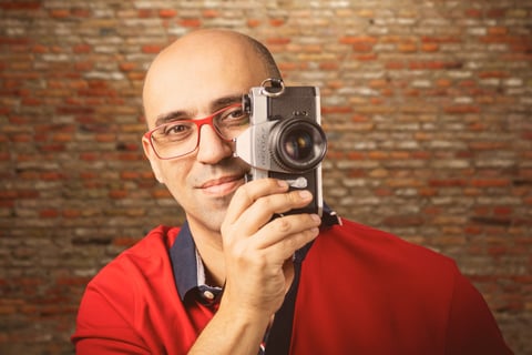 O fotógrafo Júlio Reis segurando uma camera antiga, dada pelo seu pai