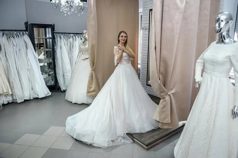 mariée heureuse en essyage de robe mariee debout dans salon