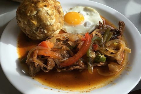 Bolon de verde with fried egg and a meat stew