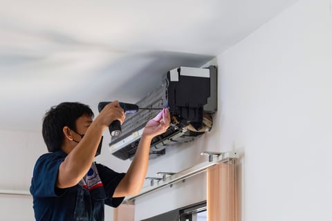 a man is fixing a air conditioner