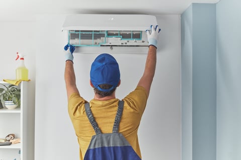 a man in overalls and a blue hat is holding a remote control unit