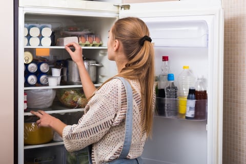 a woman standing and uninstalling the refrigerator