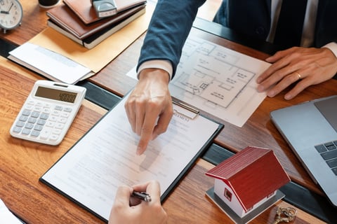 Realtor showing a client information on a contract