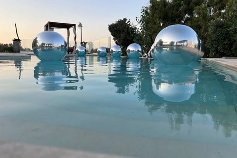 Elegant silver balloons floating beautifully above a luxurious poolside wedding in Santorini