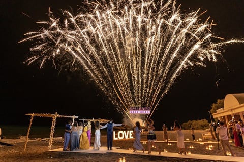 Dazzling Santorini fireworks illuminating a romantic wedding night sky.