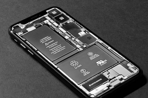Cell phone with back panel removed, revealing battery and internal components for professional batte