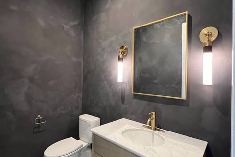 Modern black limewash bathroom with a textured matte finish, featuring elegant contrast and a moody,