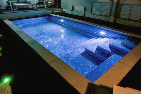 Foto kolam renang villa dengan suasana malam yang diterangi lampu taman