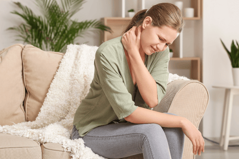 Young Woman Suffering from Neck Pain at Home