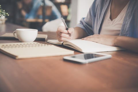 Writing by hand in a journal.