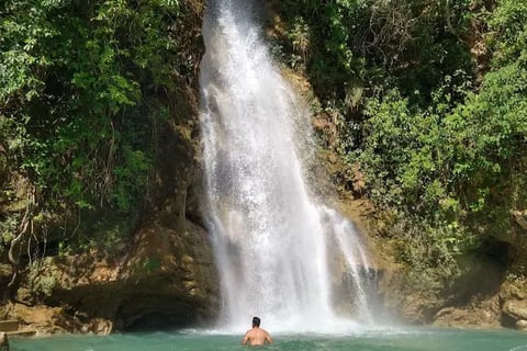 a man standing in front of a waterfall