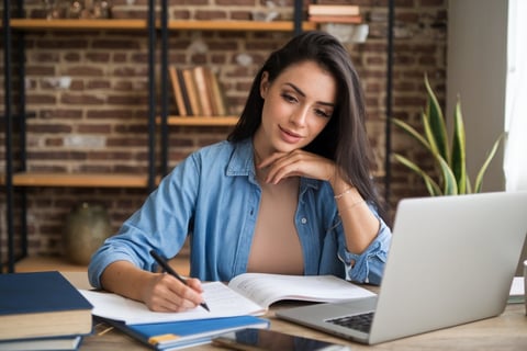 a woman sitting at a desk with a notebook and pen