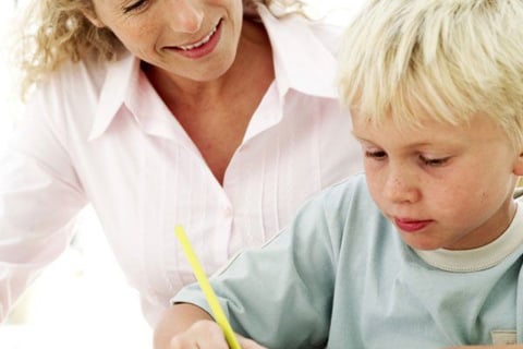 Graphothérapeute professionnelle accompagnant un jeune élève à perfectionner sa technique d'écriture à Conflans-Sainte-Honori