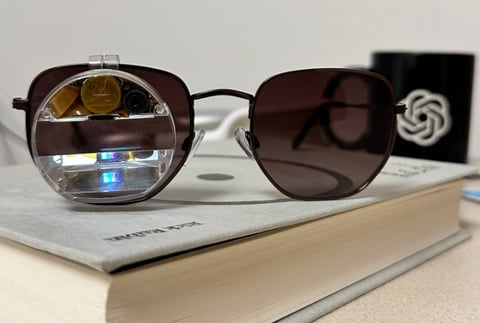 a pair of AI sunglasses and a book on a book