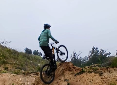 This image shows a rider leaning over the bars at the lip of the jump, leading to a nose-heavy postu