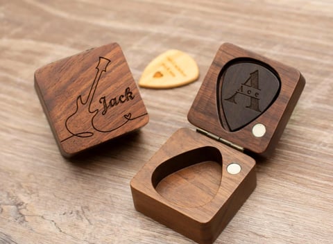 a wooden box with a guitar pickle on it