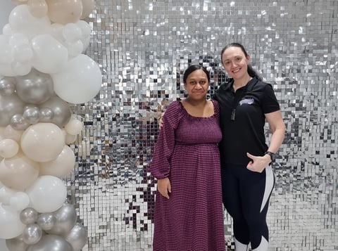 Carly from SweetAz Co. and Denise's sister in front of the silver shimmer wall hired for her graduation in Brisbane