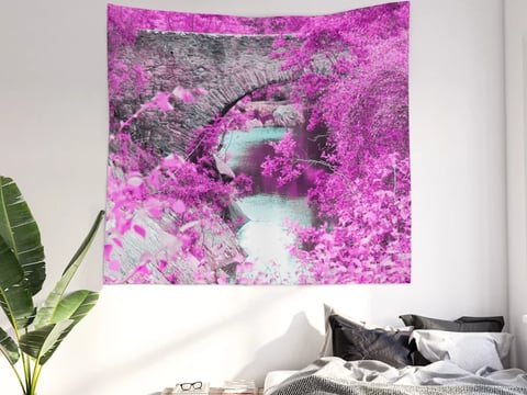 Wall tapestry of fantasy bridge hanging on wall with bed underneath this.