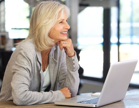 a woman sitting at a table with a laptop