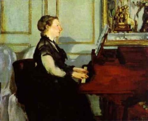 a woman in a black dress sitting at a piano
