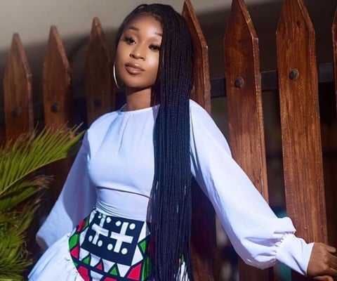 Efia Odo posed in a white top and material skirt.