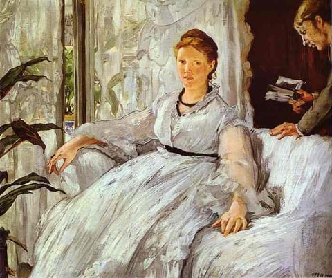 a woman in a white dress sitting on a couch
