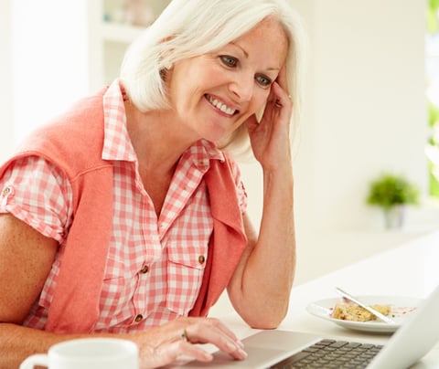 a woman sitting at a table with a laptop computer