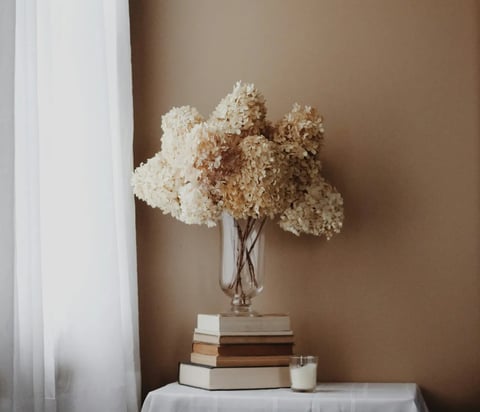 Fleurs séchées sur des livres, symbolisant un espace calme de ressources énergétiques et de clarté s