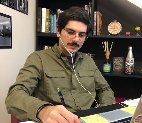 a man in a green shirt is sitting at a desk