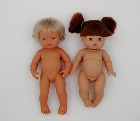 a Miniland doll next to a Minikane doll