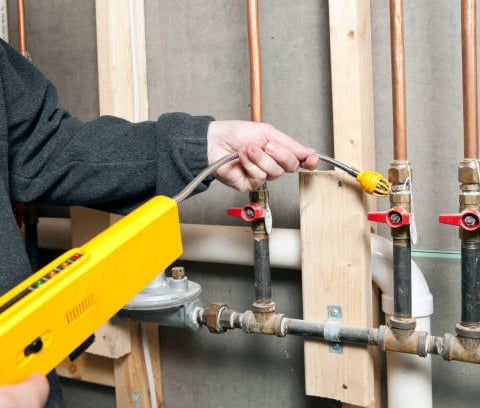 plumber scanning a pipe for leaks