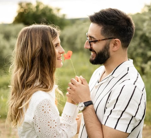 Provence engagement photographer — couple smiling, holding a poppy flower