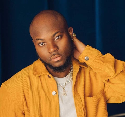 King Promise in a brown vest.