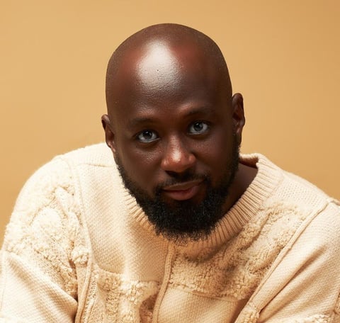 Kofi Karikari in a brown sweater.